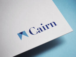 cairn logo mockup onto white board, in full colour
