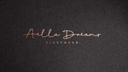aella dreams logo mockup with the graphic reproduced in gold foil and debossed into dark coloured paper board