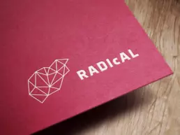RADIcAL logo mockup printed in white onto textured maroon coloured board