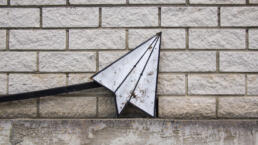 A street sign of a paper aeroplane