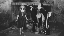 a vintage black and white photograph of a woman casting a spell on a young assistant