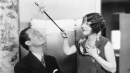 vintage photograph of a woman holding a magic wand over a man's head