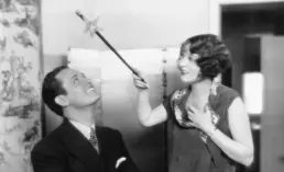 vintage photograph of a woman holding a magic wand over a man's head