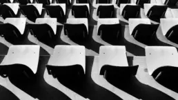 A black and white photo of empty auditorium seats