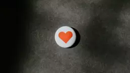 A badge with a heart on a dark background