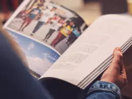 a view from behind a person reading a printed magazine