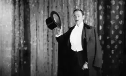 a vintage magician poses in black and white