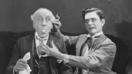 two men perform a magic trick in a vintage photograph