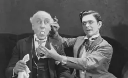 two men perform a magic trick in a vintage photograph