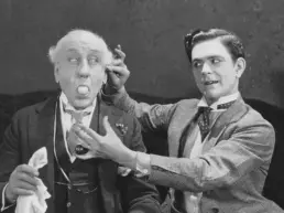 two men perform a magic trick in a vintage photograph